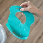 Мек силиконов лигавник Roll n Go Tommee Tippee, навива се на компактно руло за лесно прибиране, тюркоазен цвят, 6м+ 0146.004